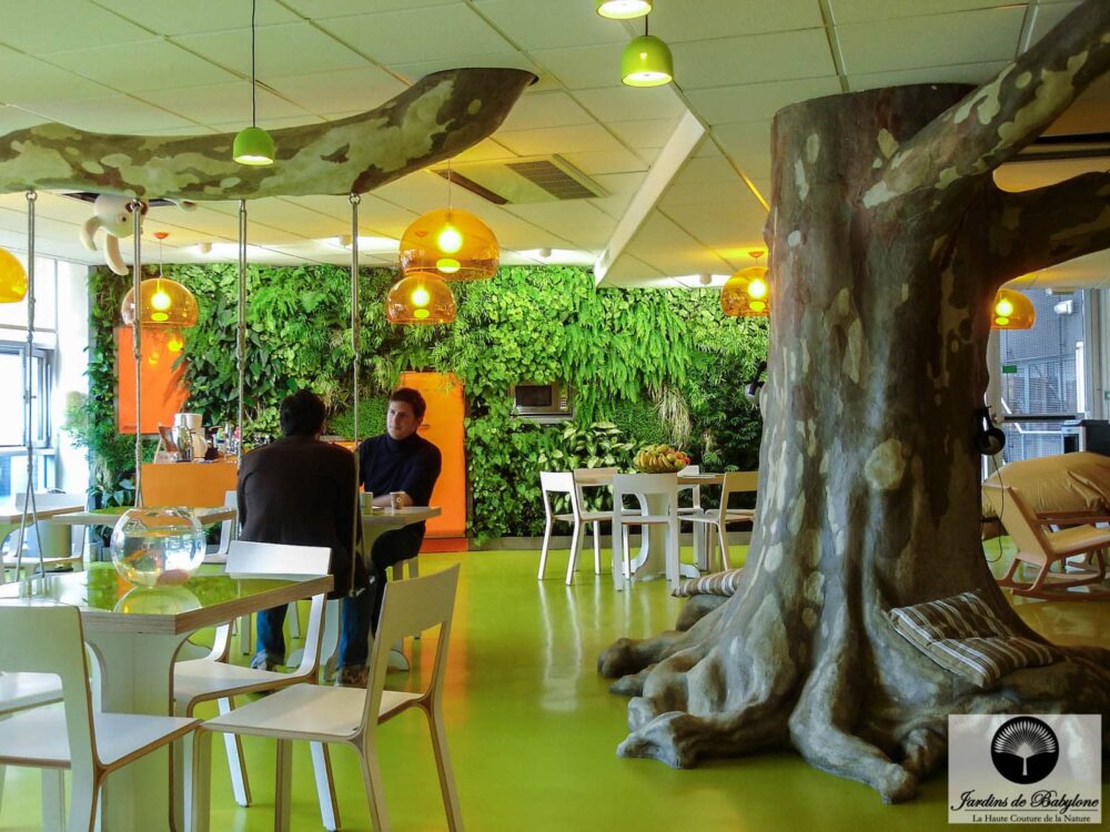 faux arbre en face d'un mur végétal